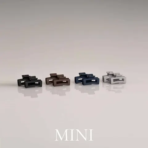 Fyra mini-hårklämmor i svart, chokladbrun, marinblå och ljusgrå – produktbild på rad med matt finish