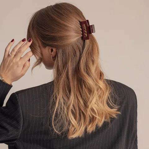 Small-hårklämma i glansig burgundy – halvt uppsatt hår på modell i studio